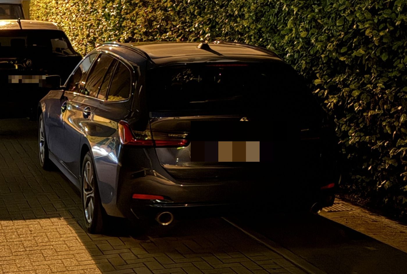 Auto vor der Hecke außerhalb der Flächen bei Nacht